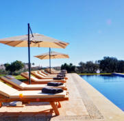 Pool und Liegen mit Sonnenschutz an einem sonnigen Tag auf unserer luxuriösen Finca Es Clape auf Mallorca