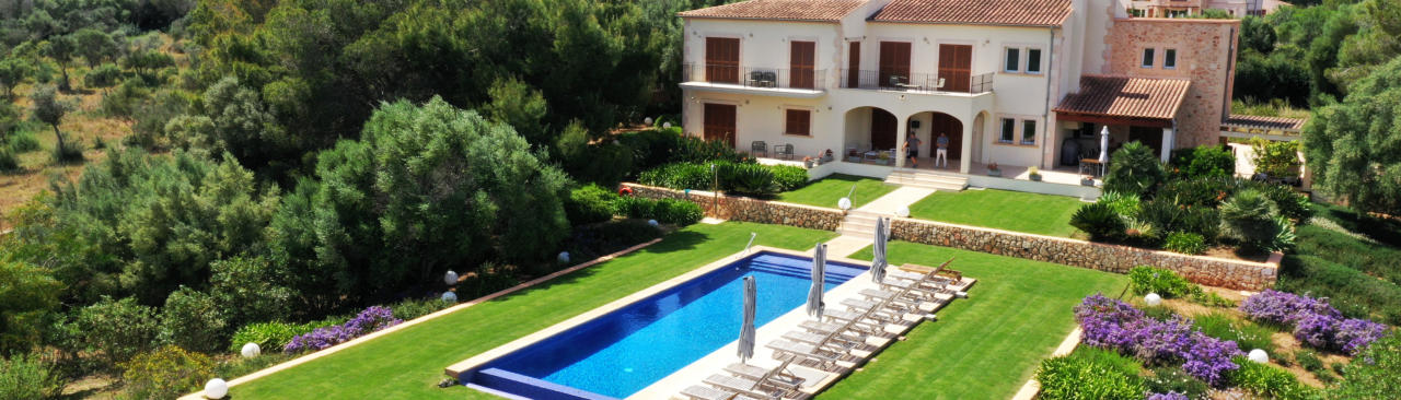 Finca Es Clape mit einem großen Pool, Liegen und einem exklusiven Garten an einem Sonnentag