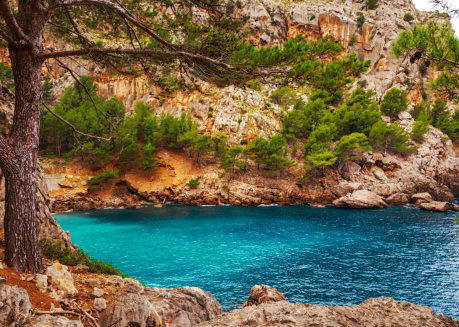 Hellblauer See umgeben von Klippen und Steinen auf Mallorca