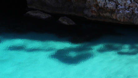 Hellblaues Meer an einer Steinwand auf Mallorca